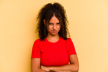 Young Brazilian woman isolated on yellow background unhappy looking in camera with sarcastic expression.