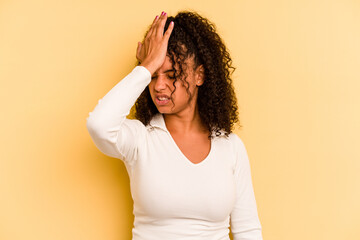 Young Brazilian woman isolated on yellow background forgetting something, slapping forehead with...