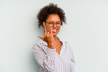 Fototapeta na wymiar Young Brazilian woman isolated on blue background showing rock gesture with fingers