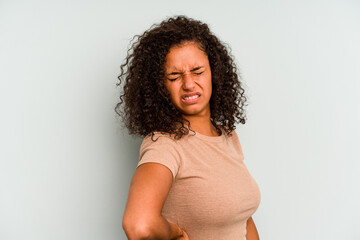 Young Brazilian woman isolated on blue background suffering a back pain.