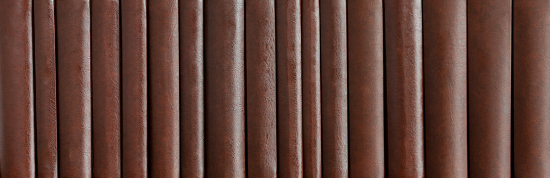 Close-up of book spines. Empty brown leather book spines background texture banner.