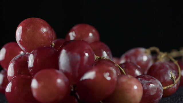 still life of grapes with black background