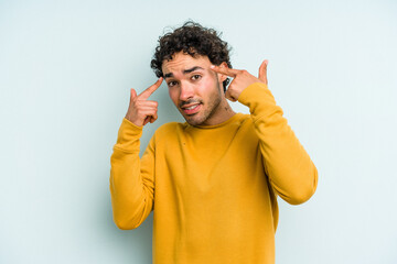 Young caucasian man isolated on blue background showing a disappointment gesture with forefinger.