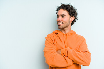 Young caucasian man isolated on blue background smiling confident with crossed arms.