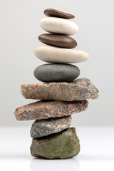 pyramid of stacked stones on a light background. stabilization and balance in life