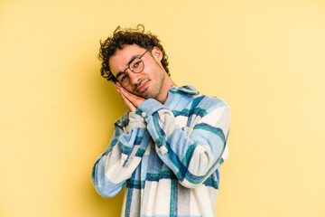 Obraz premium Young caucasian man isolated on yellow background yawning showing a tired gesture covering mouth with hand.