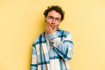 Young caucasian man isolated on yellow background doubting between two options.