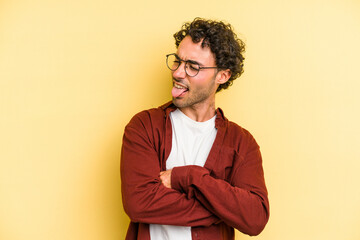 Obraz premium Young caucasian man isolated on yellow background funny and friendly sticking out tongue.