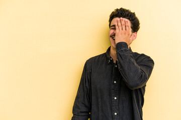 Young caucasian man isolated on yellow background laughing happy, carefree, natural emotion.