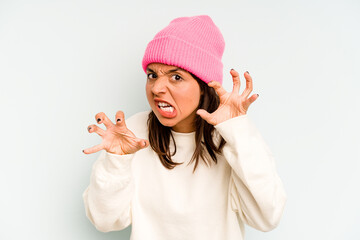 Young hispanic woman isolated on blue background laughs and closes eyes, feels relaxed and happy.