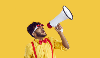 Screaming in megaphone. Funny Indian man in humorous clothes makes loud advertisement on vivid...