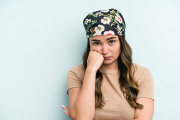 Young caucasian woman isolated on blue background who feels sad and pensive, looking at copy space.