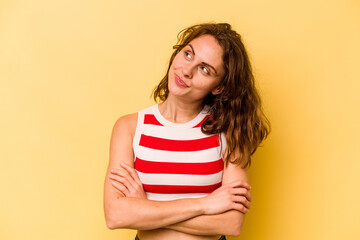 Young caucasian woman isolated on yellow background dreaming of achieving goals and purposes