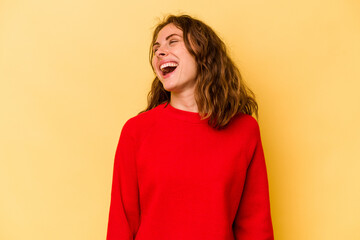 Young caucasian woman isolated on yellow background relaxed and happy laughing, neck stretched showing teeth.