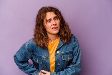 Young caucasian woman isolated on purple background having a liver pain, stomach ache.