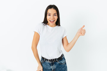 Cheerful young woman smiling and showing thumb up