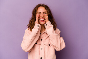 Young caucasian woman isolated on purple background saying a gossip, pointing to side reporting something.