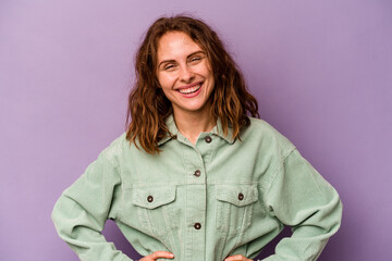Young caucasian woman isolated on purple background happy, smiling and cheerful.