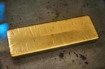 A rectangular bar of gold lies in a tub under water.