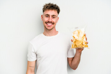 Young caucasian man holding crisps isolated on white background happy, smiling and cheerful.