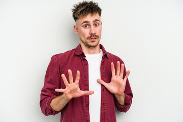 Young caucasian man isolated on white background rejecting someone showing a gesture of disgust.