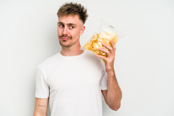 Young caucasian man holding crisps isolated on white background