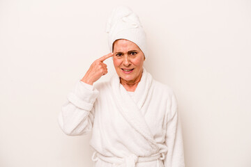 Middle age caucasian woman wearing a bathrobe isolated on white background showing a disappointment gesture with forefinger.