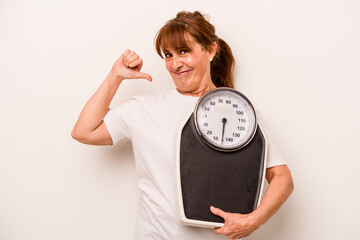 Middle age caucasian woman holding a scale isolated on white background feels proud and self...