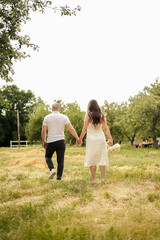 Naklejka na ściany i meble bride and groom walking through the woods at a wedding photo shoot
