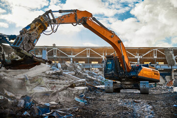 Excavator with hydraulic scissors cuts concrete beams
