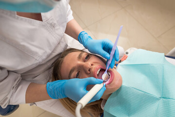 Dentist-hygienist conducts a teeth cleaning procedure for a girl in a dental clinic. Removal of tartar.