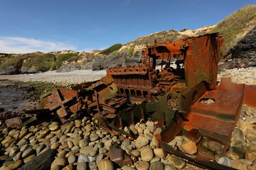 Fototapeta na wymiar Shipwreck on a stony beach by the ocean sea in Portugal