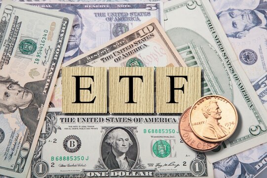 exchange-traded fund (ETF) is a type of pooled investment security. The word is written on money and gold background