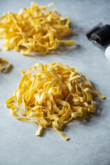 Fresh uncooked pasta nests on a gray background. Close up.