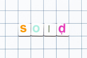 Colorful tile letter in word sold on white grid background