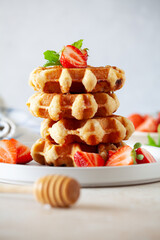 Stack of homemade waffles with organic strawberries