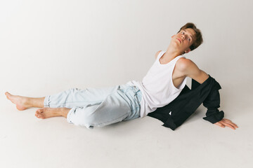 Fototapeta premium Portrait of young man, teen, student posing isolated over white studio background. Concept of fashion, youth, emotions, facial expression, ad