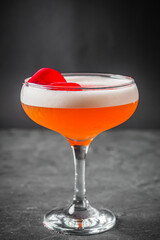 bright colored alcoholic cocktail on a black stone background