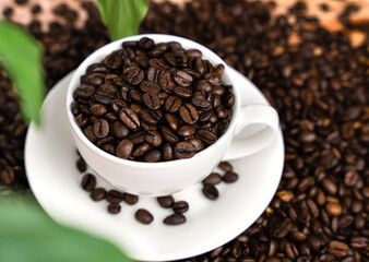 Aromatic coffee beans in a white cup. International coffee day. Close-up. Selective focus.