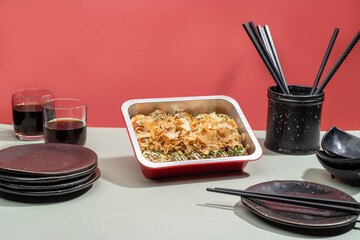 TAKOYAKI food tray with drinks and chopsticks isolated on grey background side view