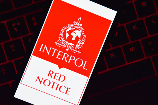 A smartphone with the Interpol logo displayed on the screen lies on the keyboard.