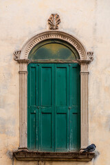 Fototapeta na wymiar Classic window with green shutters in Padua, Italy