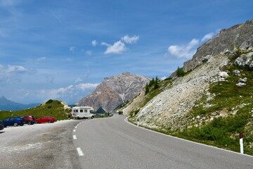 Road leading across Valparola mountain pass in Dolomite mountains in Veneto region and Belluno province in Italy and Cima Centurines mountain behind