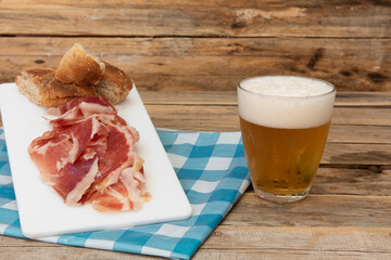 Vaso de cerveza y aperitivo de jamón ibérico