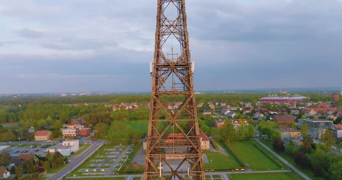 Aerial view of the wooden broadcasting tower in Gliwice with the city of Gliwice in the background. The concept of the largest wooden tower in the world. Wooden construction from a drone.