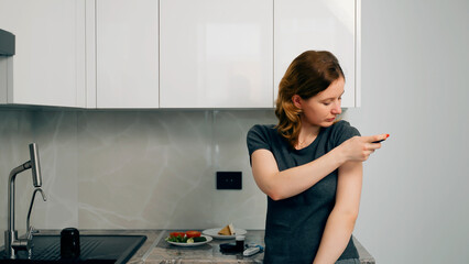 Diabetic patient using insulin pen to inject insulin at home. Young woman controls diabetes....