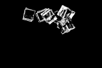 Ice cubes on a black background. ice falling on a black background for use as an illustration in a project