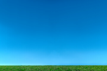 雲のない青空と緑の芝。背景用素材