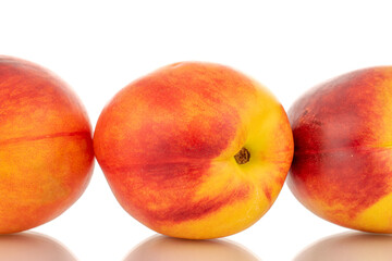 Three juicy organic nectarines, close-up, isolated on white background.