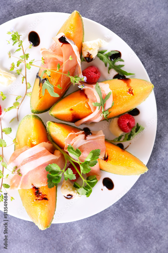 Wall mural cantaloupe melon slices with prosciutto ham and sauce - Wall murals